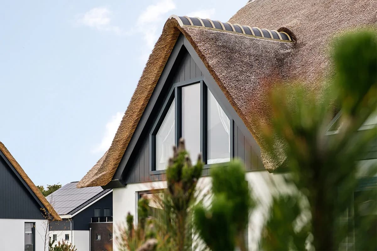 Strakke vakantievilla met rieten dak en kunststof Keralit gevel